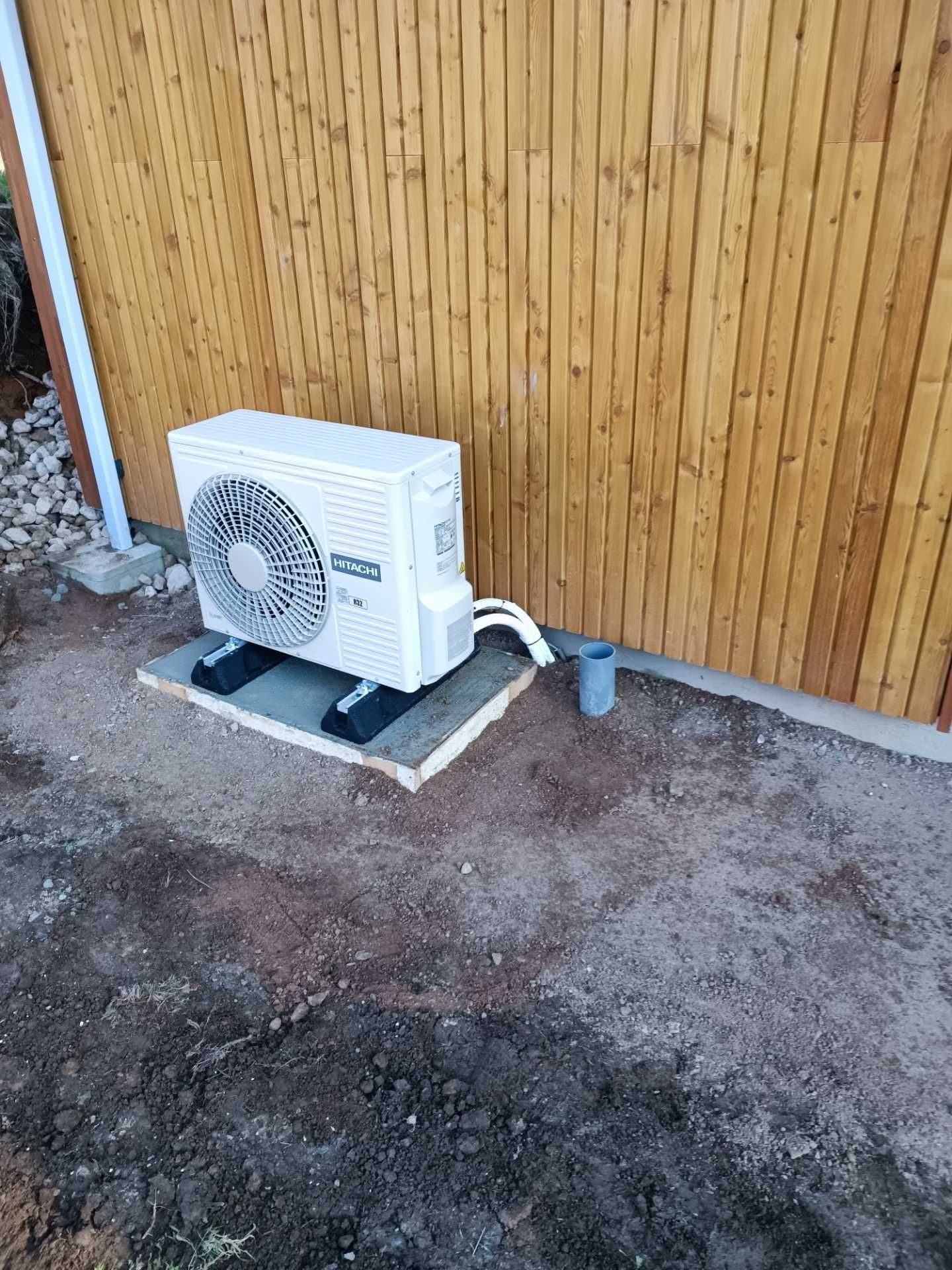 Pompe à chaleur posée contre un bardage bois
